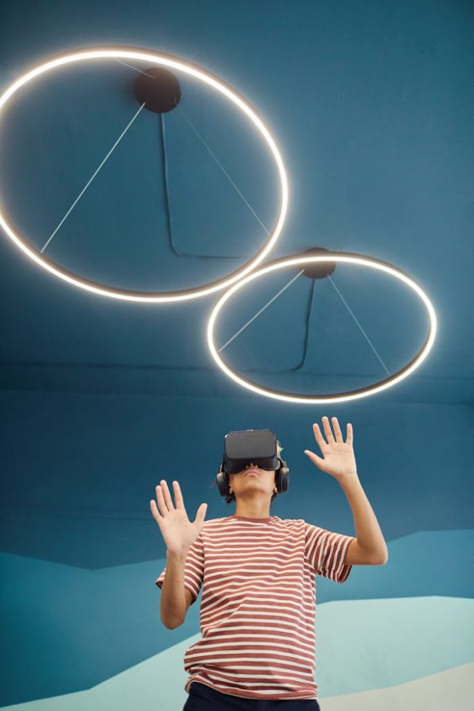 boy-standing-in-vr-headset-7869249 A young boy wearing VR headset interacting with virtual content in a modern room.